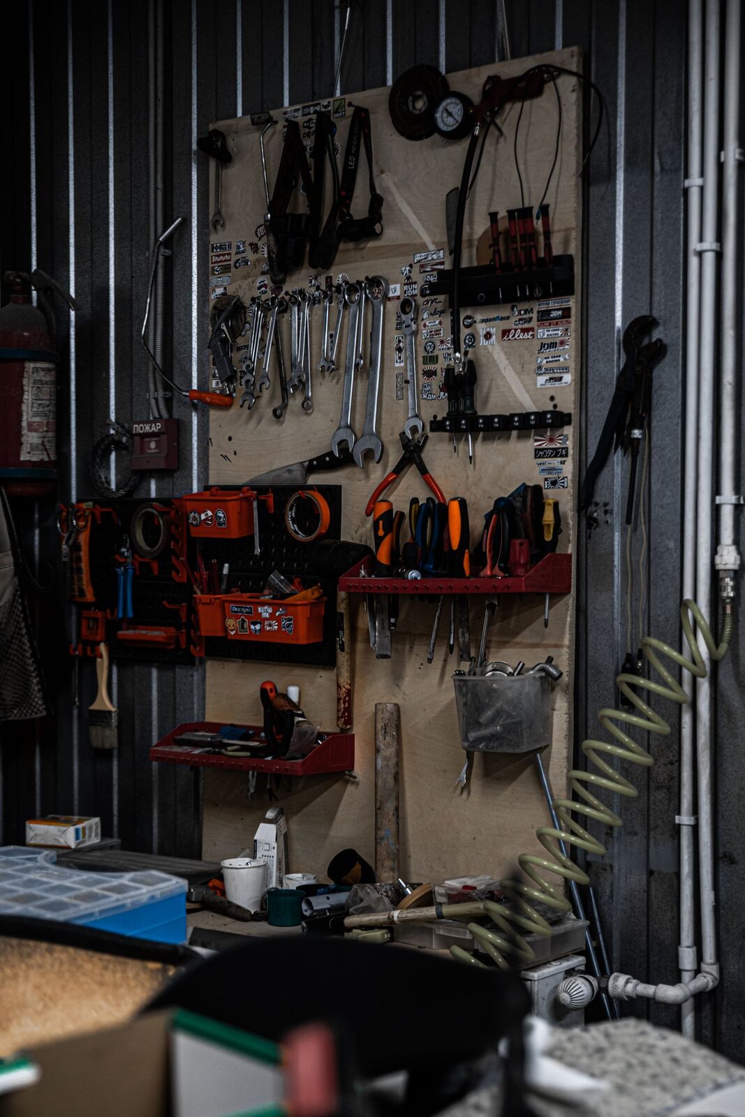 An organised garage workshop with tools on the wall